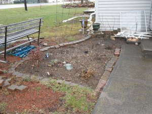 This is my flower garden.  It is looking a little sad right now.  I have a clematis which grows up the trellis, they are beautiful light blue flowers.